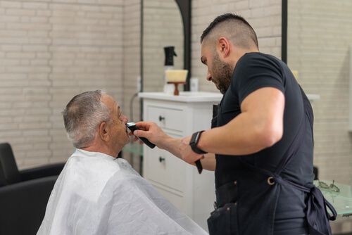 שימוש במכשיר תספורת לגבר על ידי ספר ללקוח מבוגר